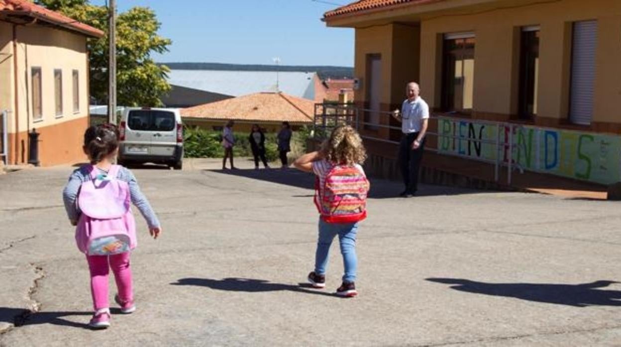 Dos niñas van a la escuela en un pueblo pequeño