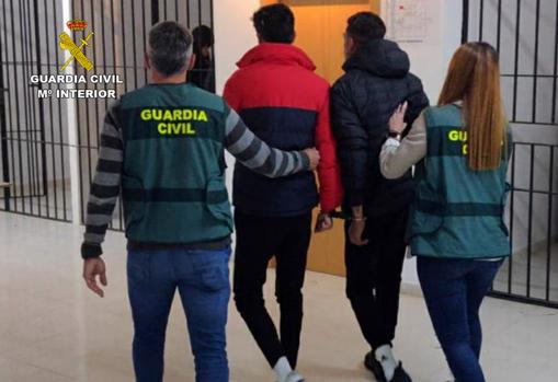 Dos de los detenidos, custodiados por la Guardia Civil