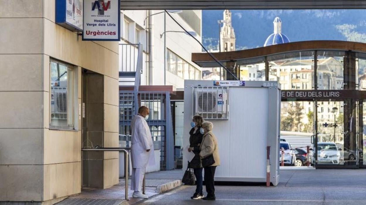 Un sanitario y dos mujeres en el acceso a Urgencias del Hospital Virgen de los Lirios de Alcoy