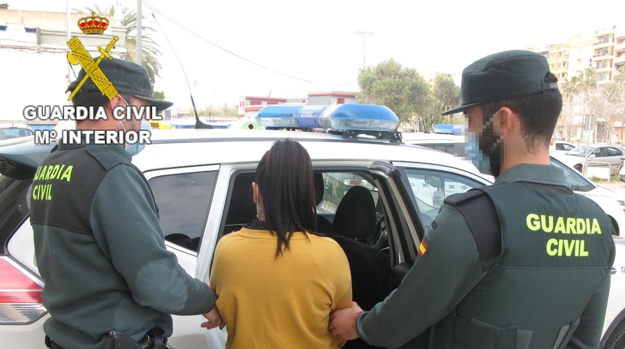 Las mujer detenida entrando al coche de la Guardia Civil de Cullera