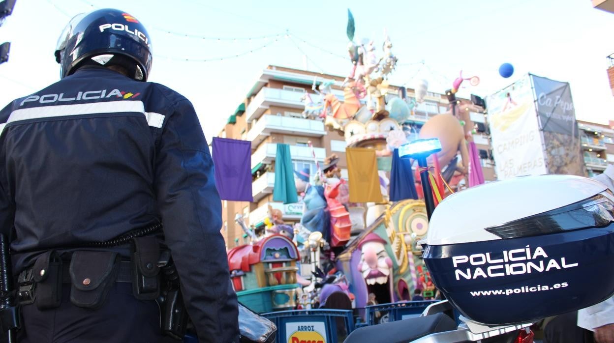 Un agente de la Policía Nacional frente a un monumento fallero en Valencia