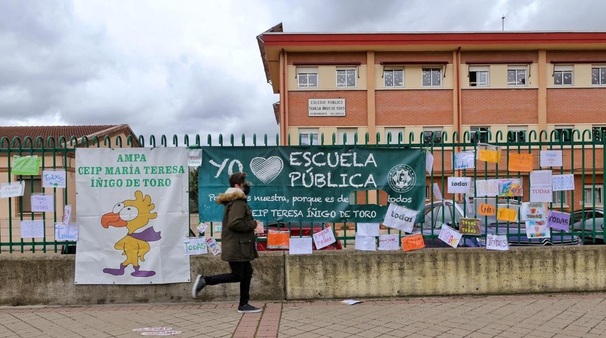 Colegio Teresa Iñígo de Toro de Valladolid con el cartel en el que se ha recortado la palabra «todas» y los letreros de protesta