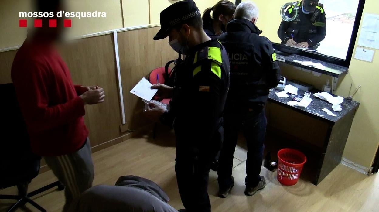 Policías durante el registro a uno de los locales de venta ilegal de lotería