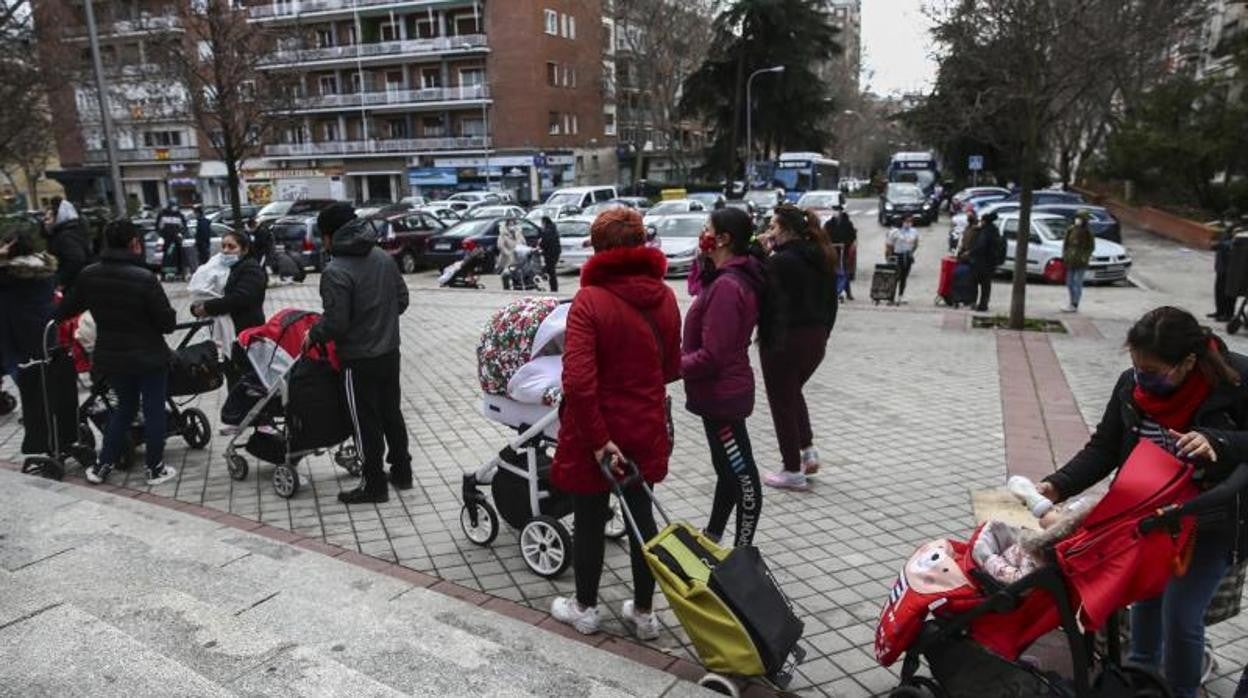 Varias personas esperan para recibir alimentos de una ONG