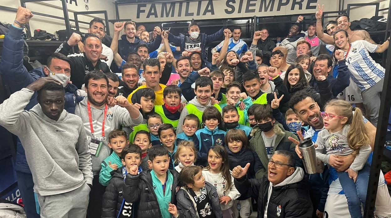 Los jugadores blanquiazules celebran la victoria con los niños en el vestuario