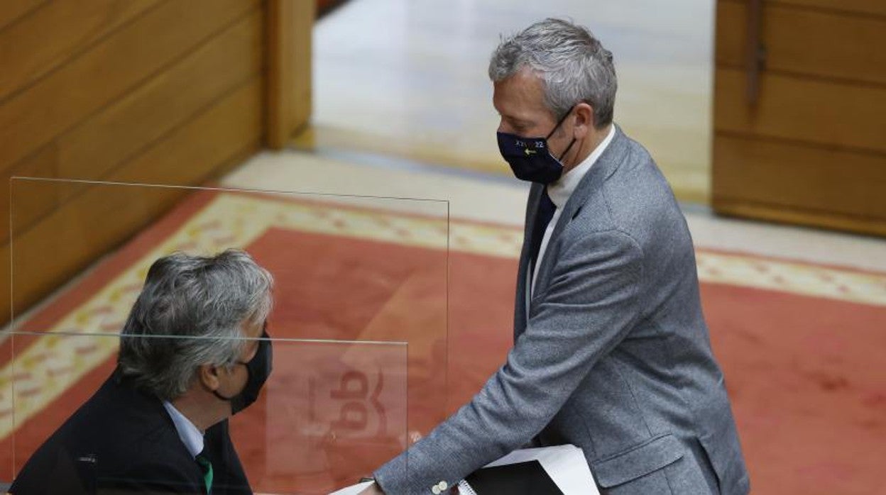 Pedro Puy y Alfonso Rueda (de pie) este lunes en el pleno del Parlamento gallego