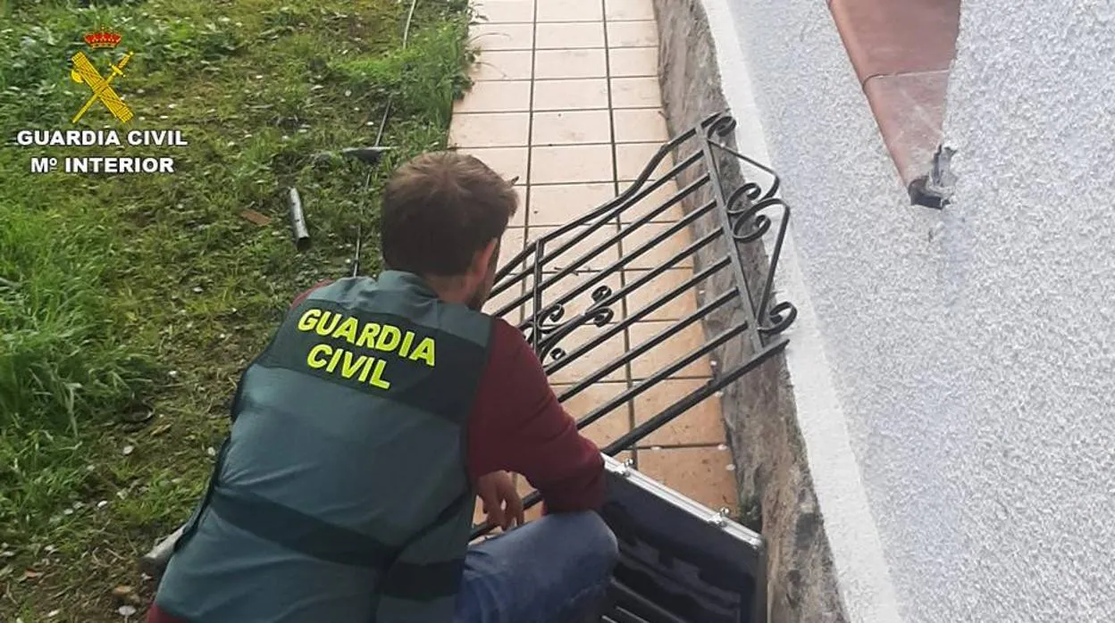 Un agente de la Guardia Civil inspecciona una de las viviendas asaltadas