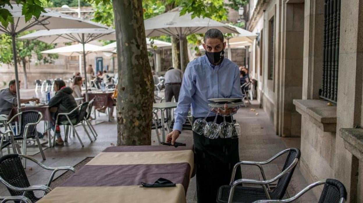 Camarero prepara una terraza en Orense