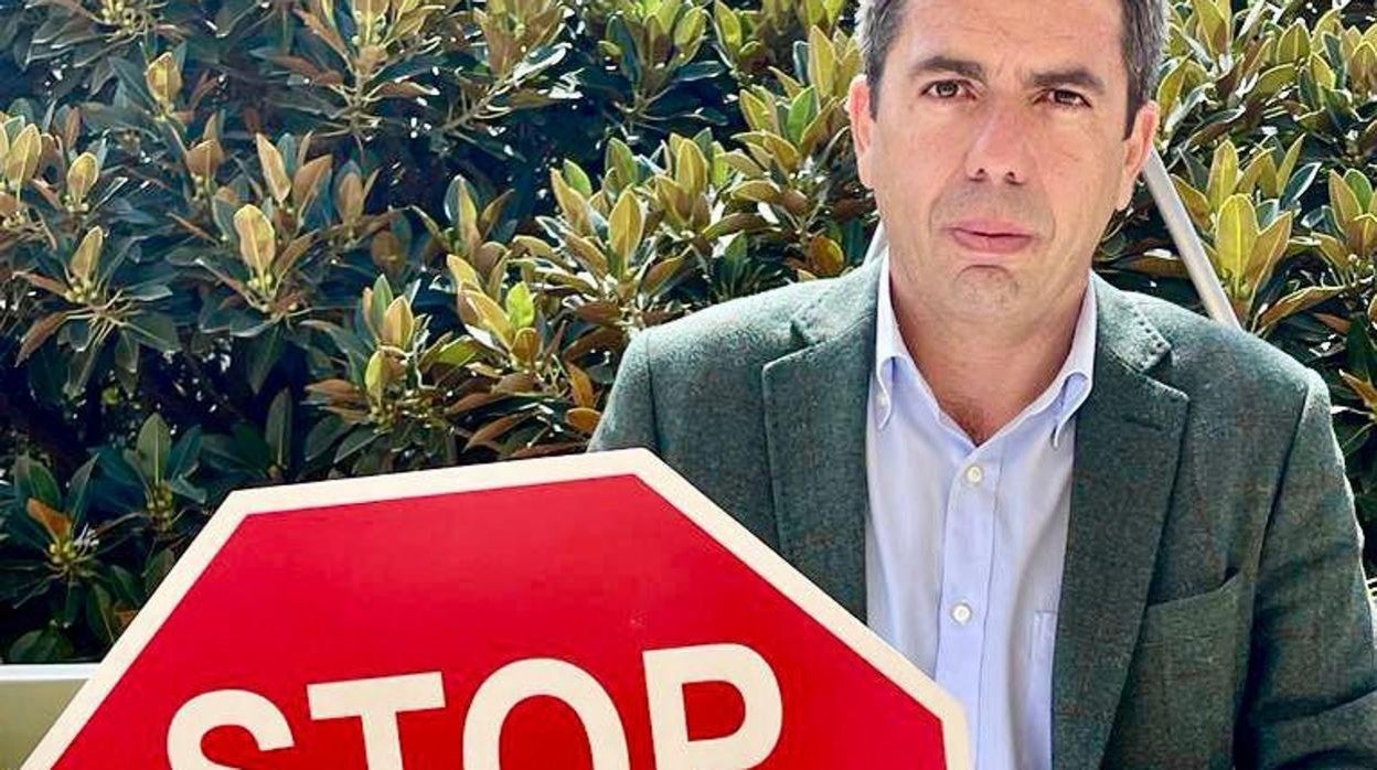 Carlos Mazón con un cartel en contra de la tasa turística