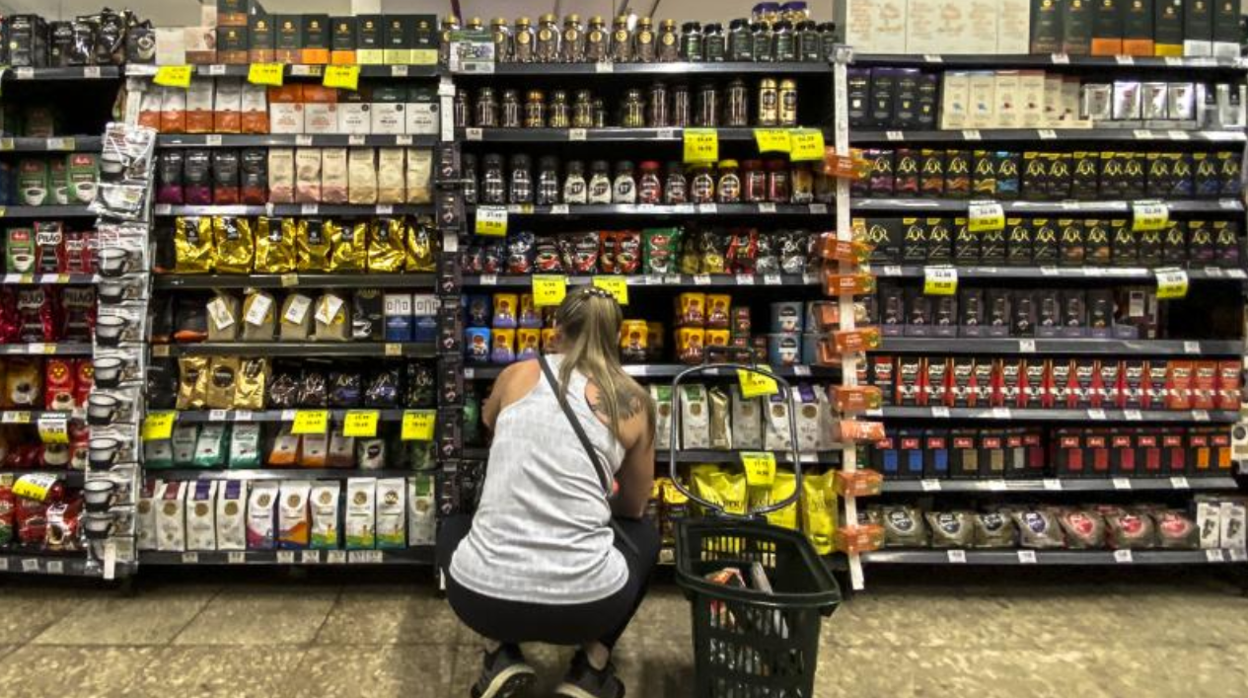 Una mujer revisa los precios en un supermercado en foto de archivo