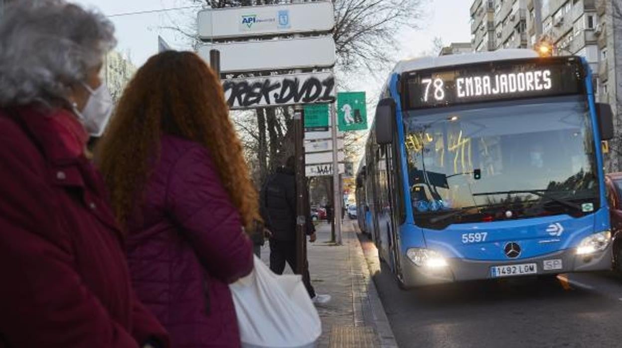 Varias pasajeras aguardan la llegada de un autobús de la EMT