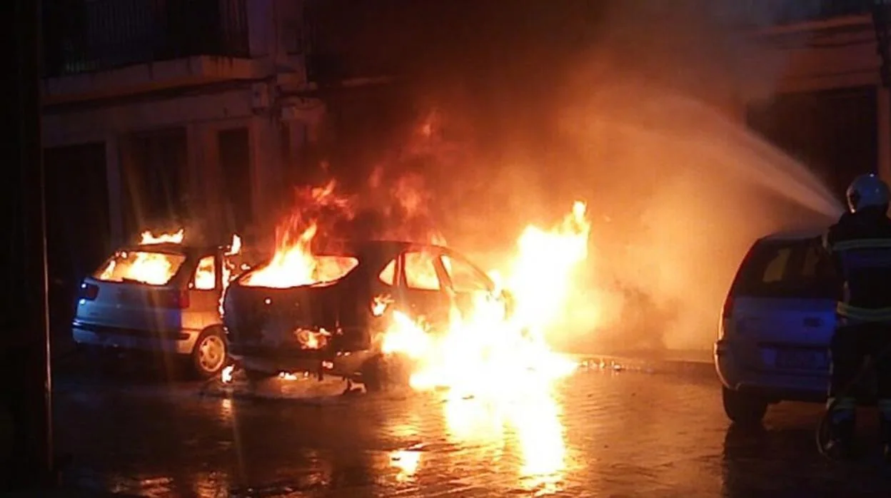 Un bombero apaga el fuego que quema dos vehículos estacionados en Caudete (Albacete)