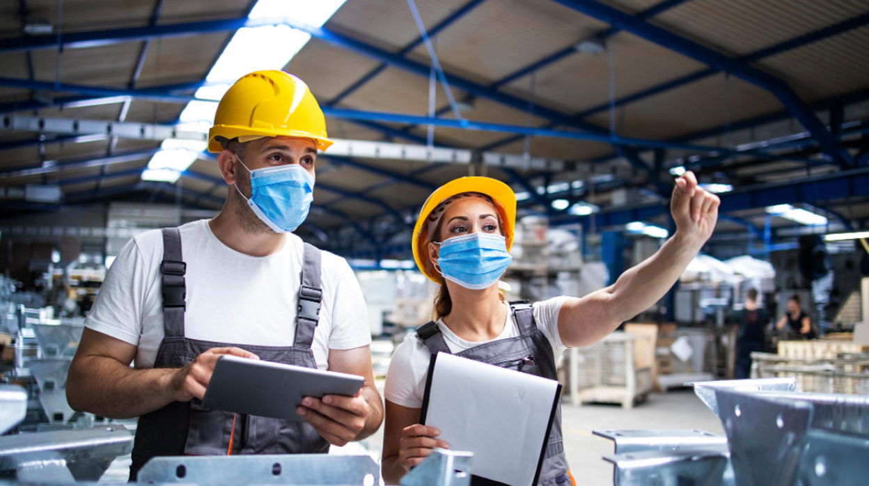 Trabajadores en una fábrica en imagen de archivo