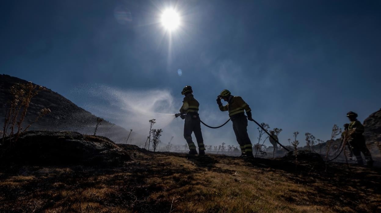 Los bomberos refrescan la tierra quemada días después del gran incendio de la sierra de la Paramera, en Ávila, el verano pasado