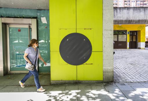 Una joven pasea por delante de otra sede de Bankia cerrada, en la calle del Poeta Joan Maragall, 16
