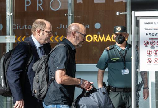 Imagen de Francis Puig (en el centro) a su entrada este lunes en la Ciudad de la Justicia de Valencia