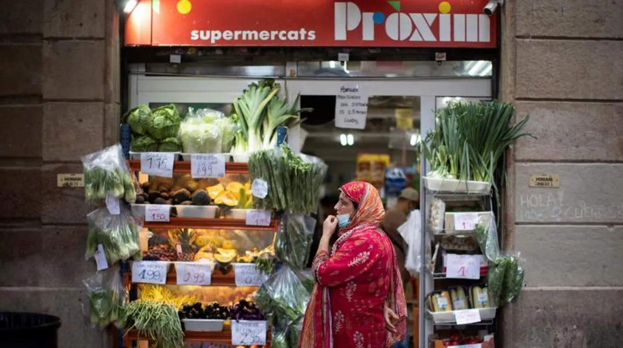 Una mujer pasea frente a un supermercado del Raval, en una imagen de archivo
