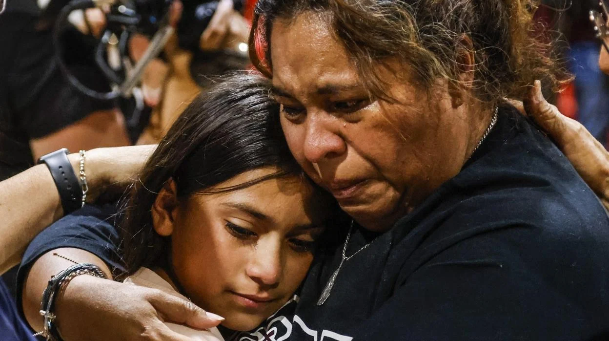Una mujer llora mientras abraza a una niña, durante una reunión de la comunidad en el recinto ferial del condado de Uvadle, tras un tiroteo masivo en la escuela primaria Robb en Uvalde, Texas, Estados Unidos