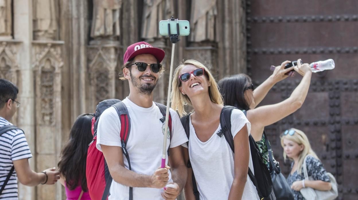 Una pareja de turistas se hace un 'selfie' delante de una iglesia