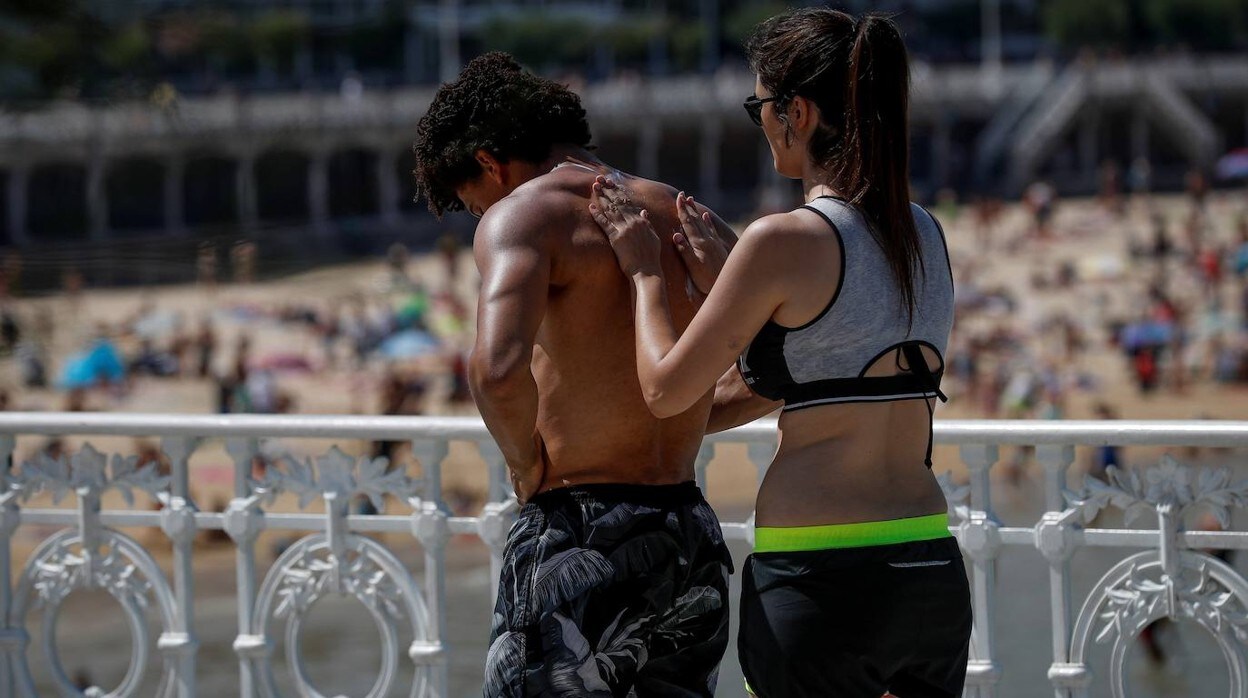 Dos turistas se protegen del sol en San Sebastián