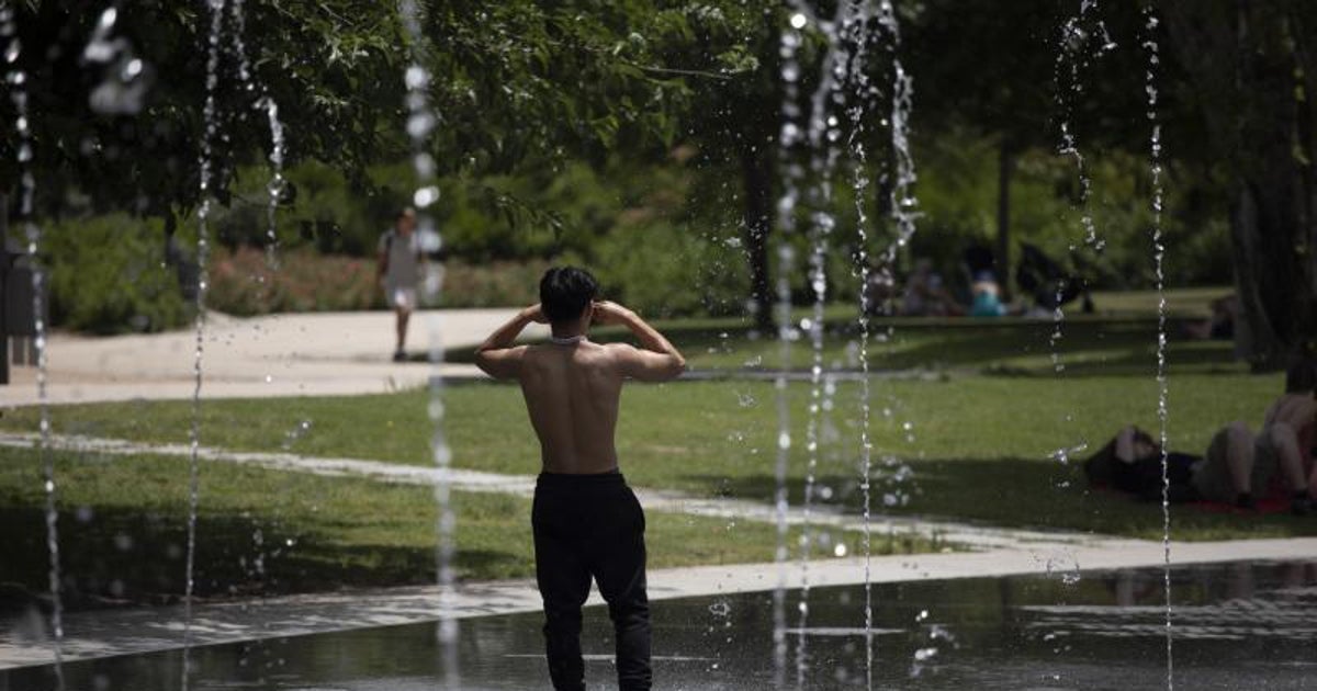 Un joven se refresca en una fuente en la capital