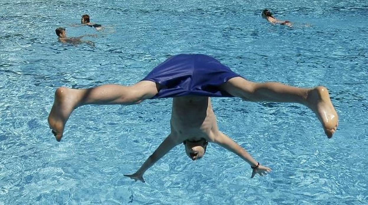 Foto de archivo de un joven lanzándose de cabeza a una piscina