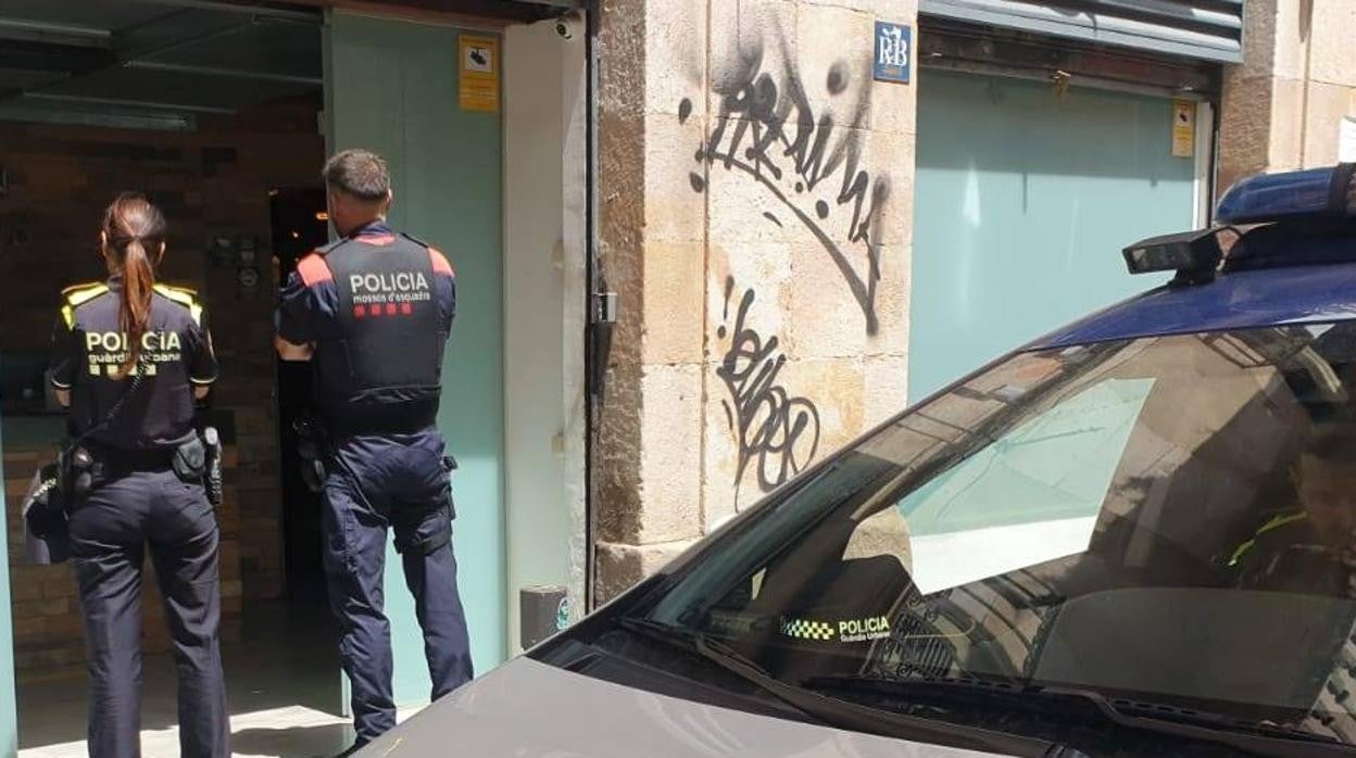 Un agente de la Urbana y otro de los Mossos durante un registro