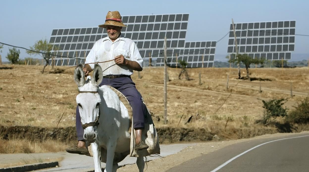 Un vecino de La Fregeneda (Salamanca) pasea junto a varios paneles solares situados a la entrada del pueblo