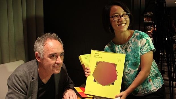 Ferán Adriá en Pekín con una joven que sostiene su nuevo libro