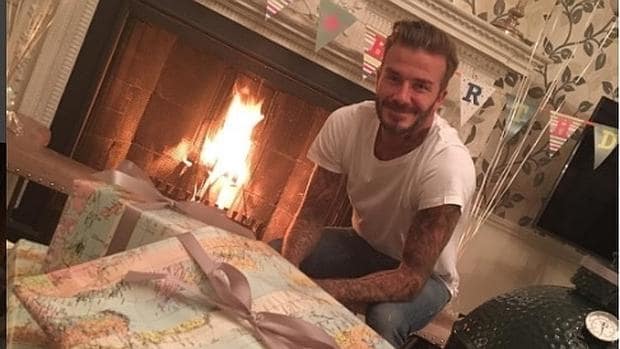 David Beckham, junto a la chimenea, a punto de abrir sus regalos