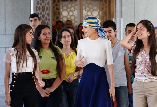 Asma Al Asad junto a un grupo de estudiantes en un acto benéfico