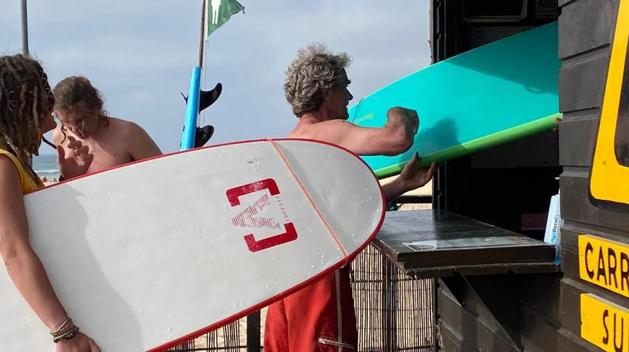 El doctor Simón cogiendo una tabla de surf