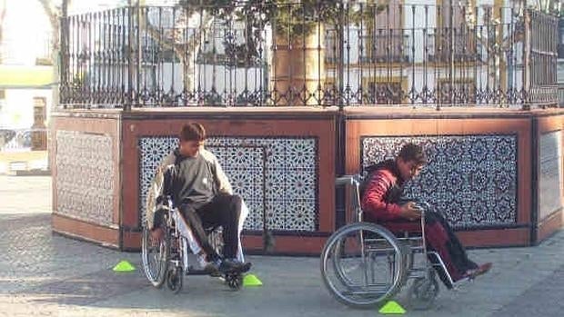 Niños jugando en su silla de ruedas.