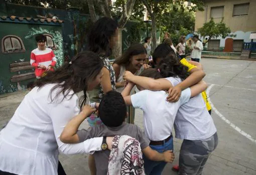 Varias voluntarias juegan con los niños tutelados en el patio de la residencia Vallehermoso