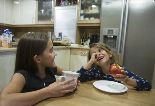 Iraide, merendando con su hermana pequeña en la cocina de su casa