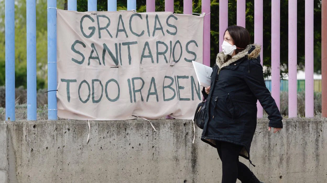 Una mujer embarazada pasa por delante de una pancarta colocada en la valla del Hospital Río Hortega de Valladolid EFE/NACHO GALLEGO