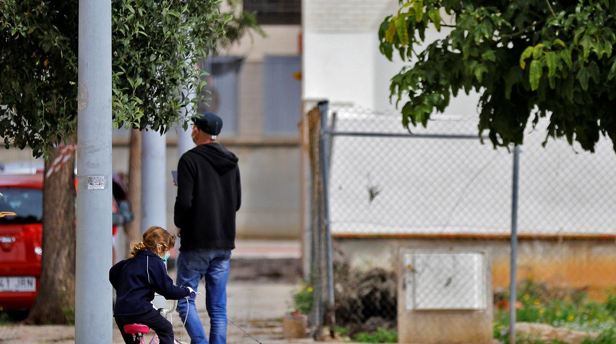 Un padre junto a su hija pasea a sus dos perros en una calle de Valencia