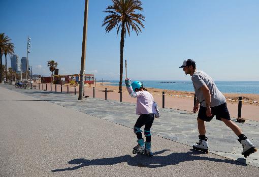 Una niña en patines disfruta de un día soleado en el paseo marítimo de Barcelona, este domingo