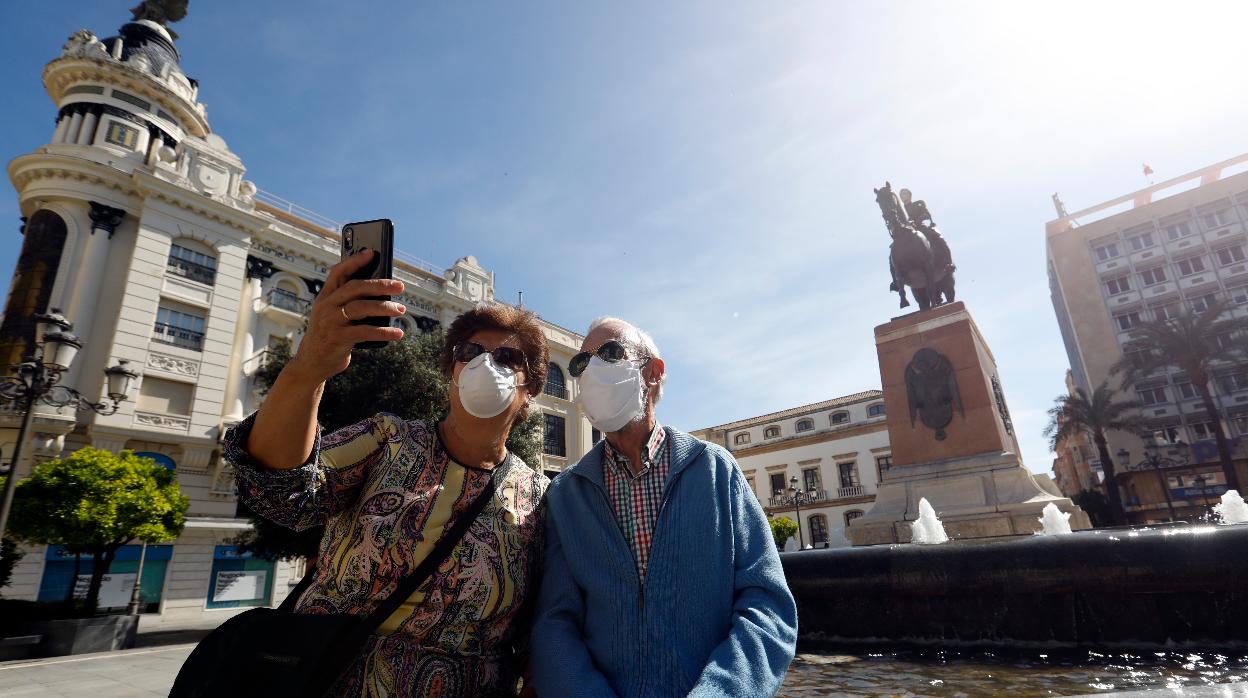 Dos personas mayores se hacen un «selfie» en Córdoba durante el paseo