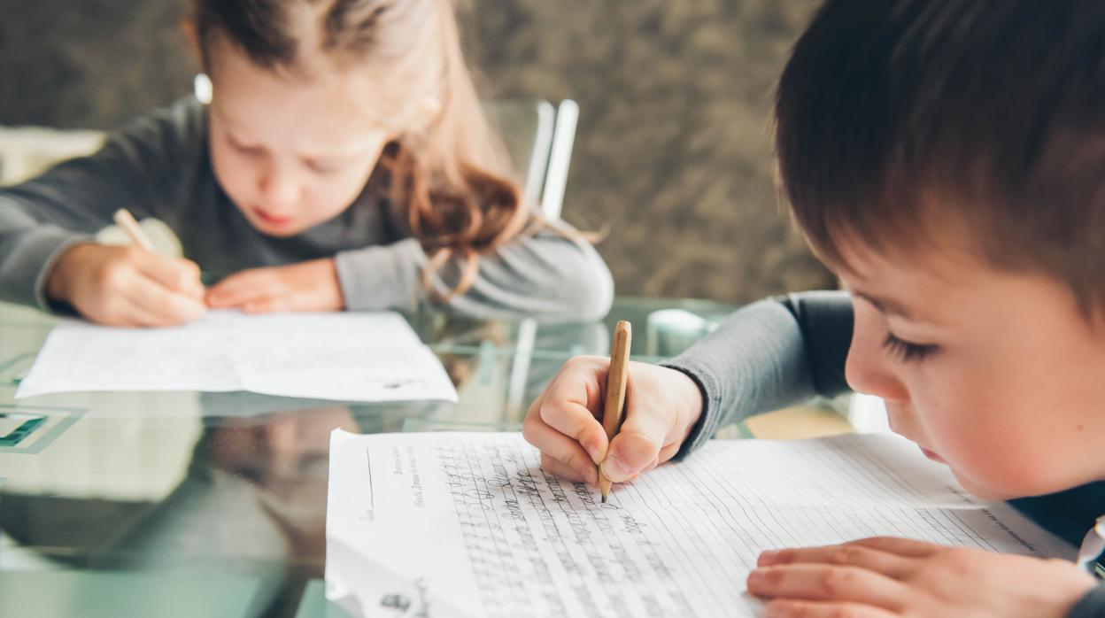 Unos niños hacen los deberes