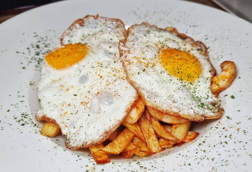 Huevos fritos con patatas y langostinos