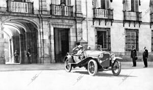 S. M. el Rey al salir de palacio en su automóvil Hispano-Suiza para una de sus...