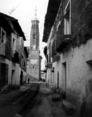 Calle mayor e iglesia parroquial de estilo Mudejar en el pueblo Paniza...
