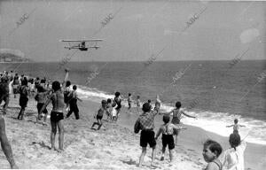 Niños refugiados en Caldetas durante la Guerra Civil saludando a un hidroavión...