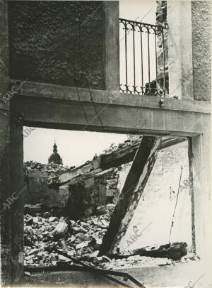 Ruinas y escombros en una casa, al fondo la torre de la Iglesia Herreriana,...