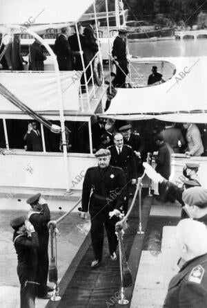 El generalísimo Franco, seguido de su Séquito, al desembarcar en el muelle de...