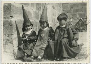 Unos niños nazarenos cansados después de la procesión