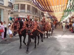 Las carrozas de caballos pasean por las calles engalanadas de la ciudad