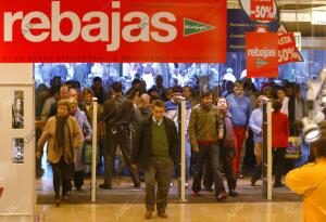 En la fotografía, la gente entra apresuradamente nada más abrir el comercio