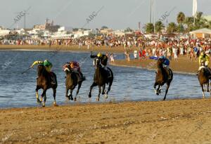 Vista de los jinetes cabalgando para alcanzar el primer puesto en la tercera...